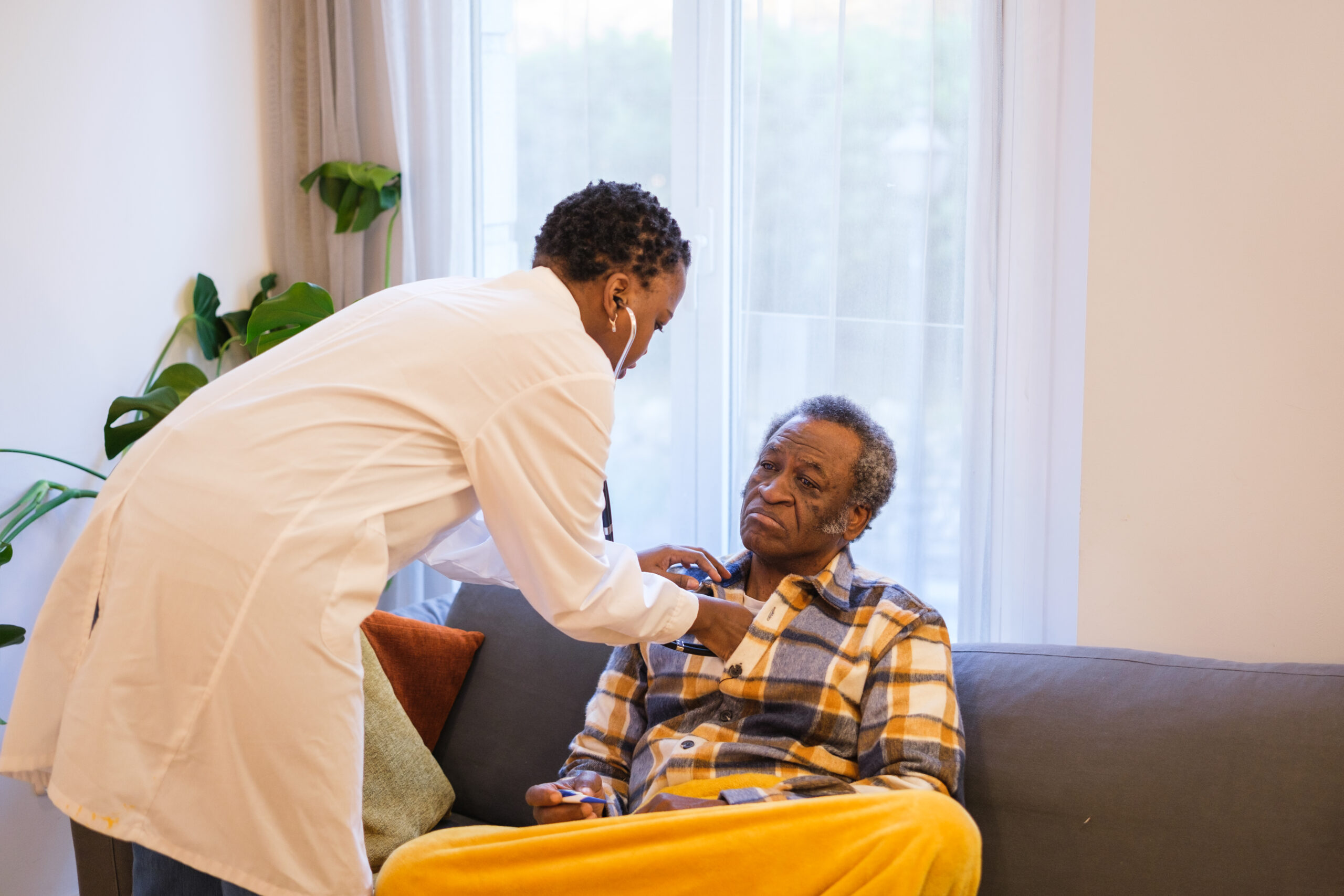 sick senior man attended by doctor with home care health care concept